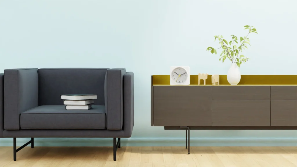Minimalist space-saving furniture including a modern grey armchair and a sleek sideboard against a light blue wall.